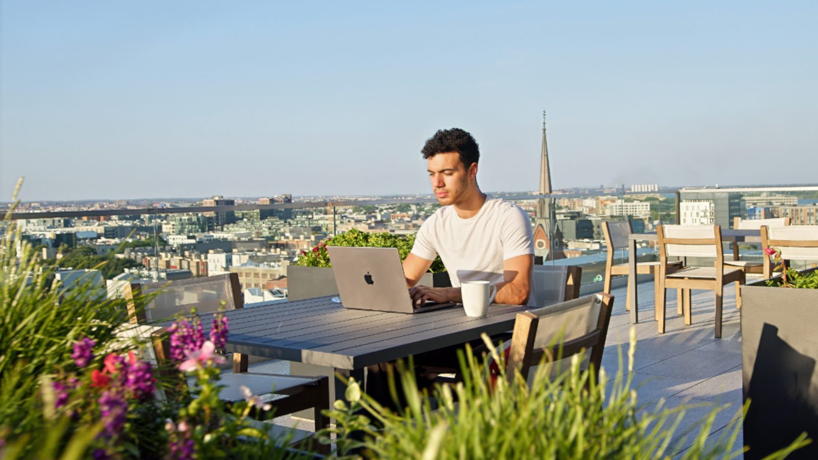 Resident working on a laptop at a rooftop table