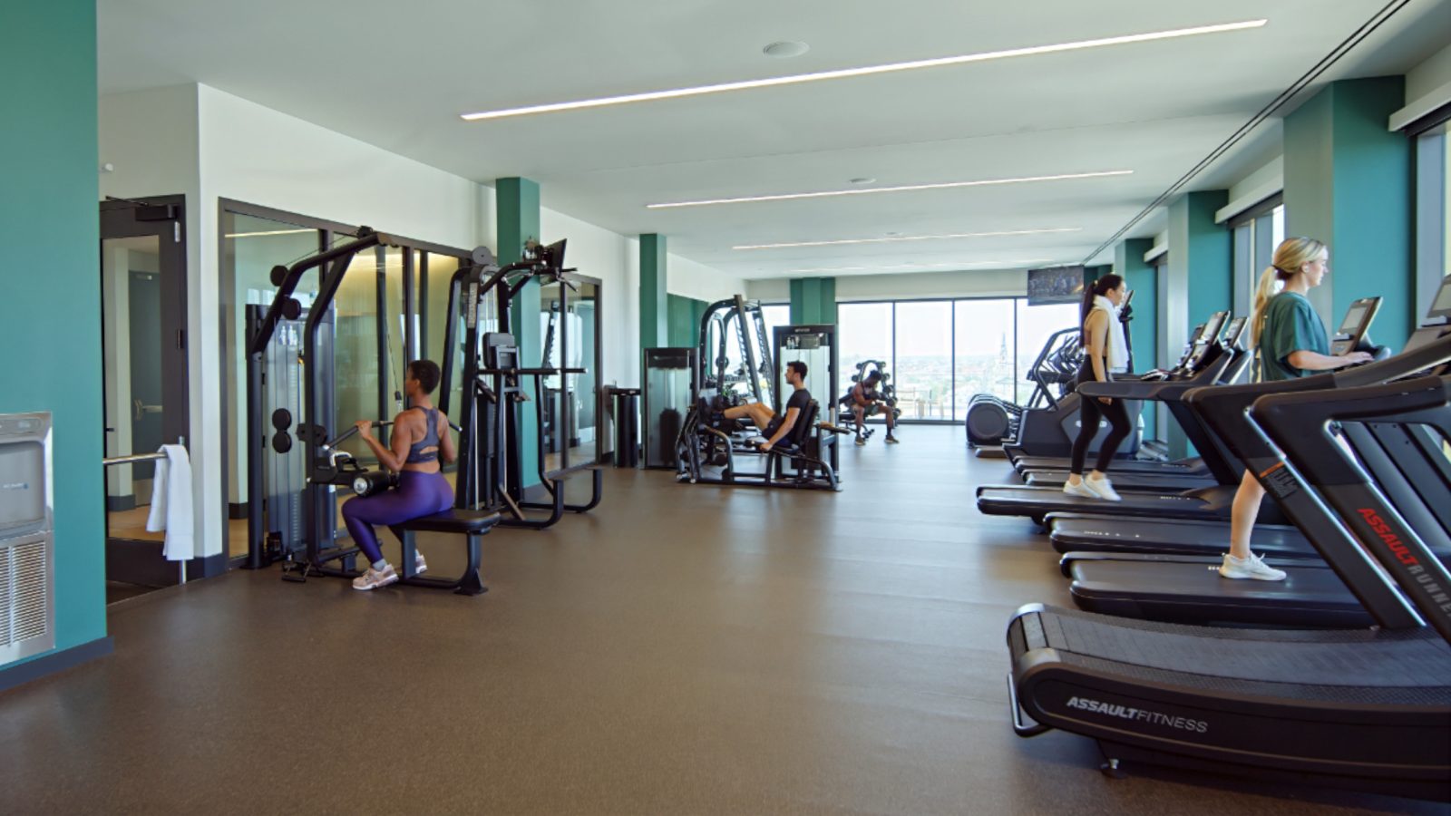 Residents using weight and cardio machines in the fitness center